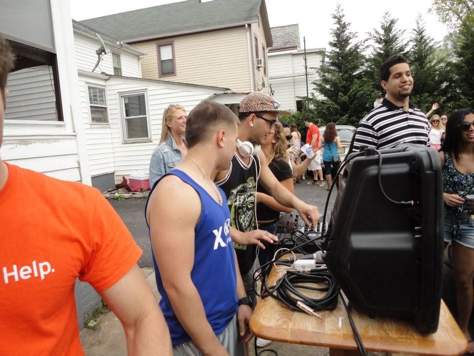 Derek DJing on a folding table at a backyard party