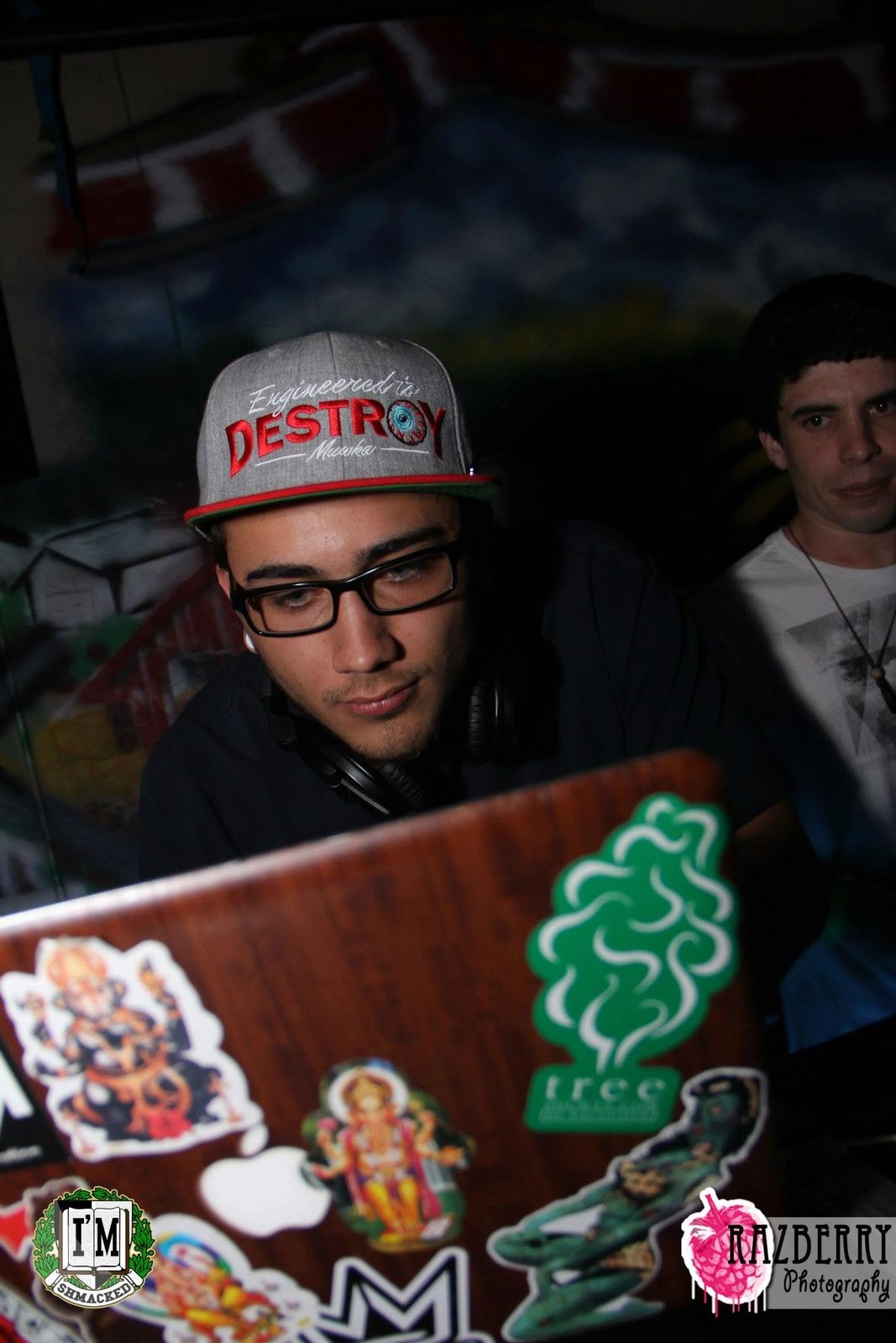 Derek behind a sticker covered laptop mid set